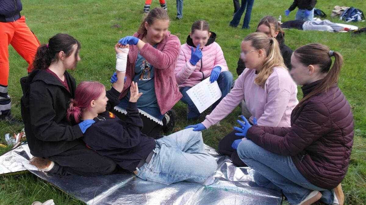 Schulsanitäter legen Druckverband an